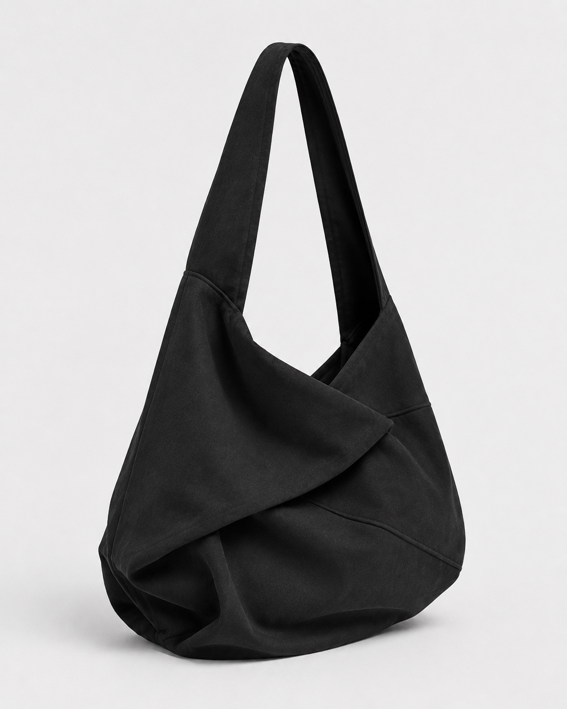 Soft black shoulder bag in three-quarter view with a folded curved body and one wide strap